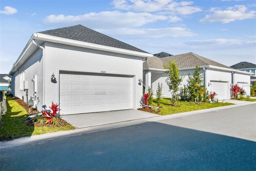 Front exterior of a new home in Emerald Landing at Waterside at Lakewood Ranch – Cottage Series, Sarasota, FL, highlighting curb appeal (Image 27). Front exterior of a new home in Emerald Landing at Waterside at Lakewood Ranch – Cottage Series, Sarasota, FL, highlighting curb appeal (Image 27).