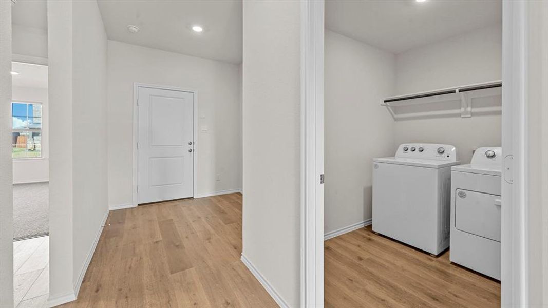 Laundry area with recessed lighting, light wood-style floors, and washing machine and dryer