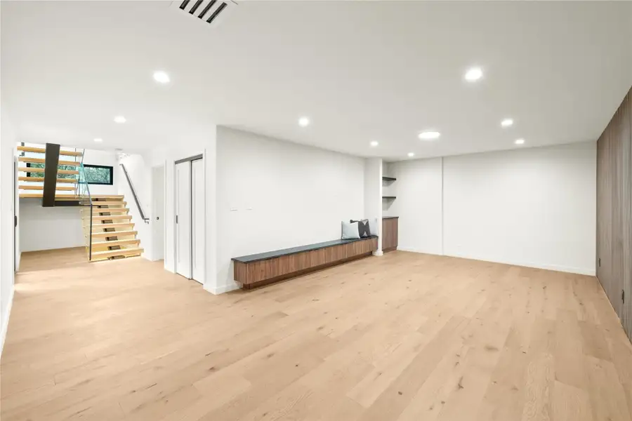 Below grade area with Media/game roomfloating staircase,  recessed lighting, light wood-style floors, and baseboards