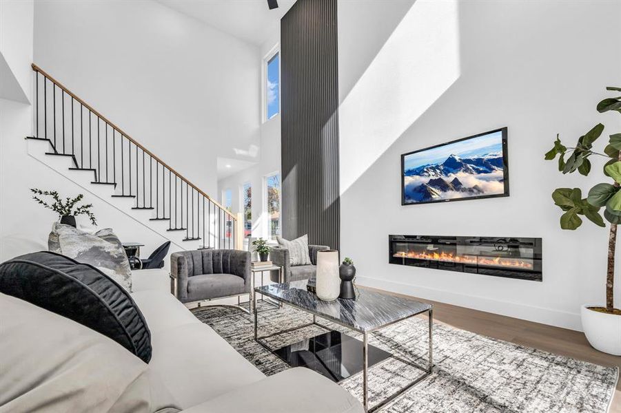 Living room featuring a towering ceiling and wood-type flooring