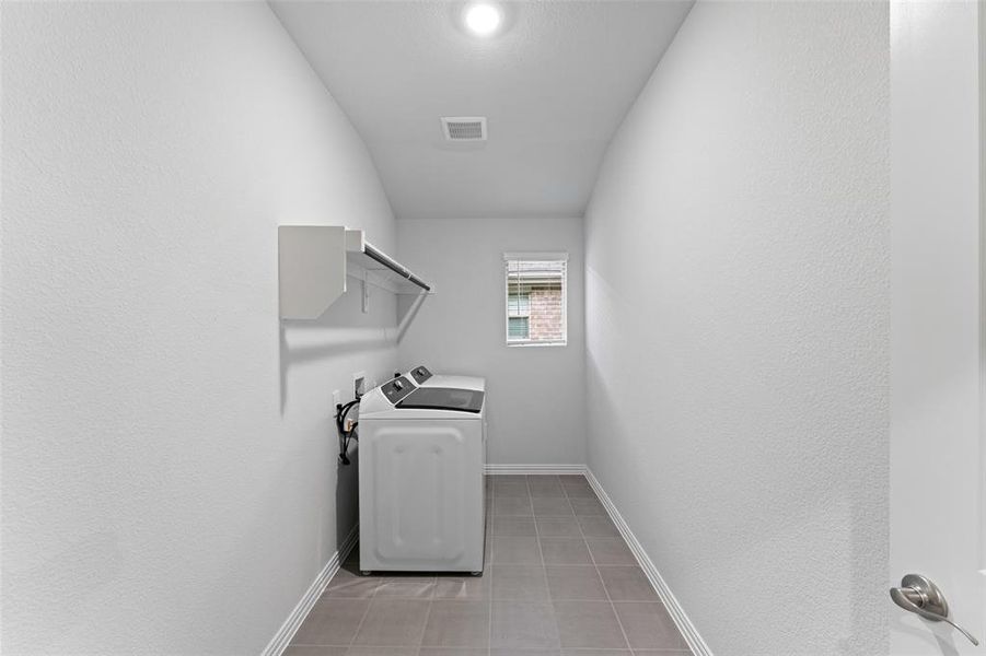 Laundry area featuring washer / clothes dryer and light tile patterned floors Laundry area featuring washer / clothes dryer and light tile patterned floors