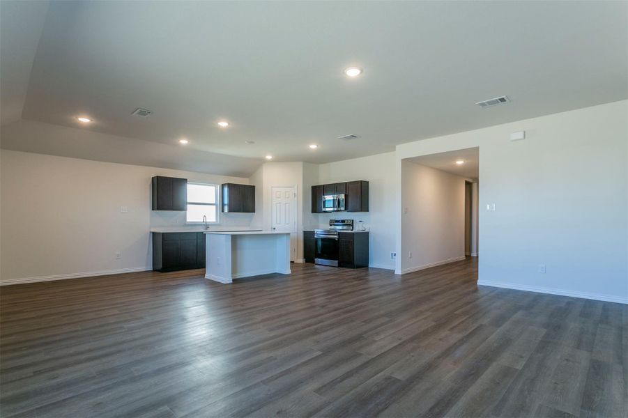 Kitchen with open floor plan, a center island, visible vents, and appliances with stainless steel finishes
