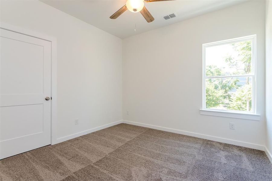 Unfurnished room with a healthy amount of sunlight and carpet floors