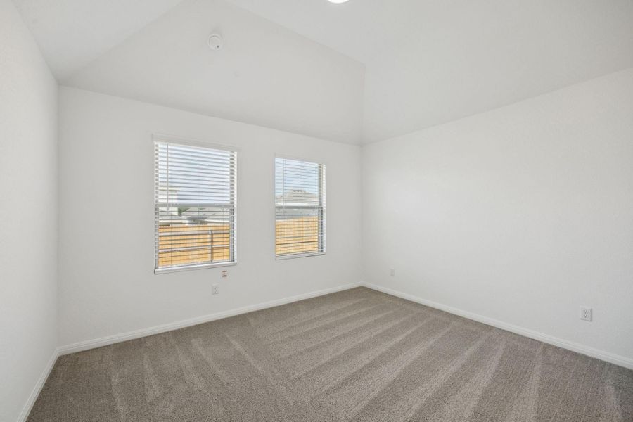 Unfurnished room featuring carpet flooring and vaulted ceiling