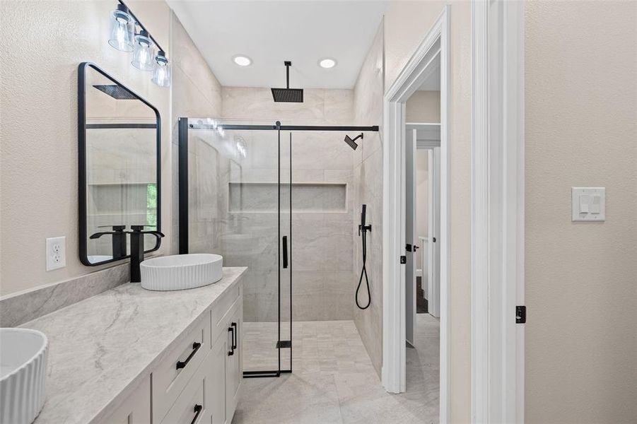 Modern bathroom featuring a double vanity with vessel sinks and light-toned countertops