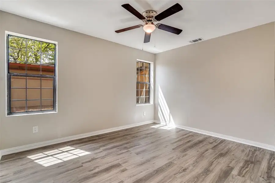Empty room with light wood-style flooring and a ceiling fan Empty room with light wood-style flooring and a ceiling fan