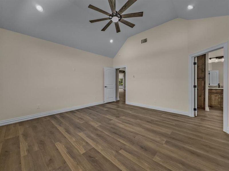 Empty room with recessed lighting, ceiling fan, dark wood finished floors, and high vaulted ceiling Empty room with recessed lighting, ceiling fan, dark wood finished floors, and high vaulted ceiling