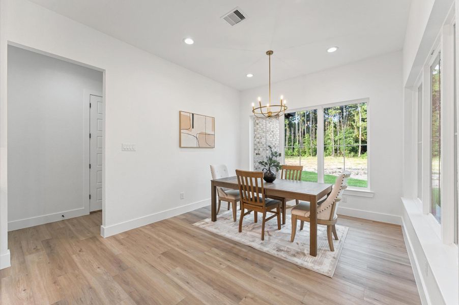 Elegant dining area perfectly situated off the kitchen overlooking the expansive backyard and pine trees. Elegant dining area perfectly situated off the kitchen overlooking the expansive backyard and pine trees.