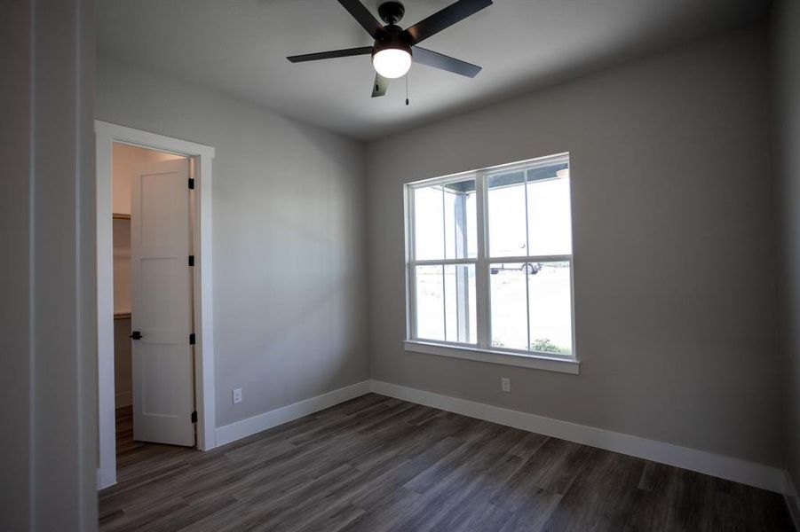 Unfurnished room featuring dark wood finished floors and ceiling fan Unfurnished room featuring dark wood finished floors and ceiling fan