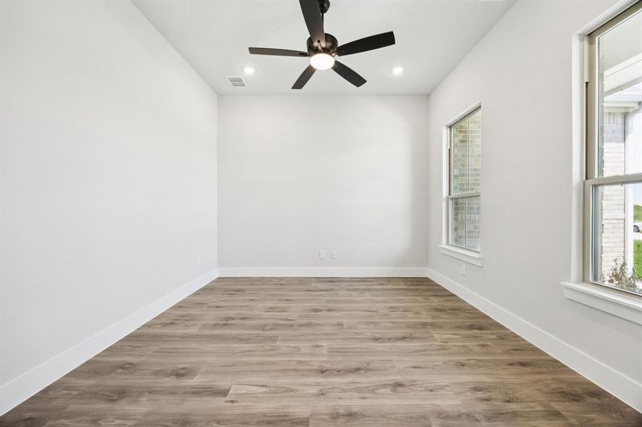 Unfurnished room featuring light wood-type flooring, plenty of natural light, a ceiling fan, and recessed lighting