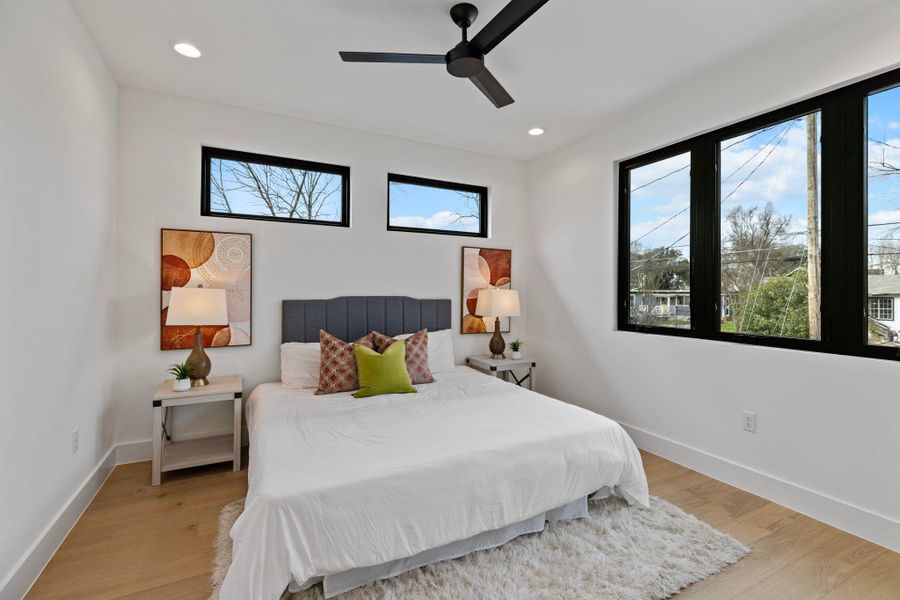 Bedroom featuring multiple windows, light wood finished floors, baseboards, and recessed lighting