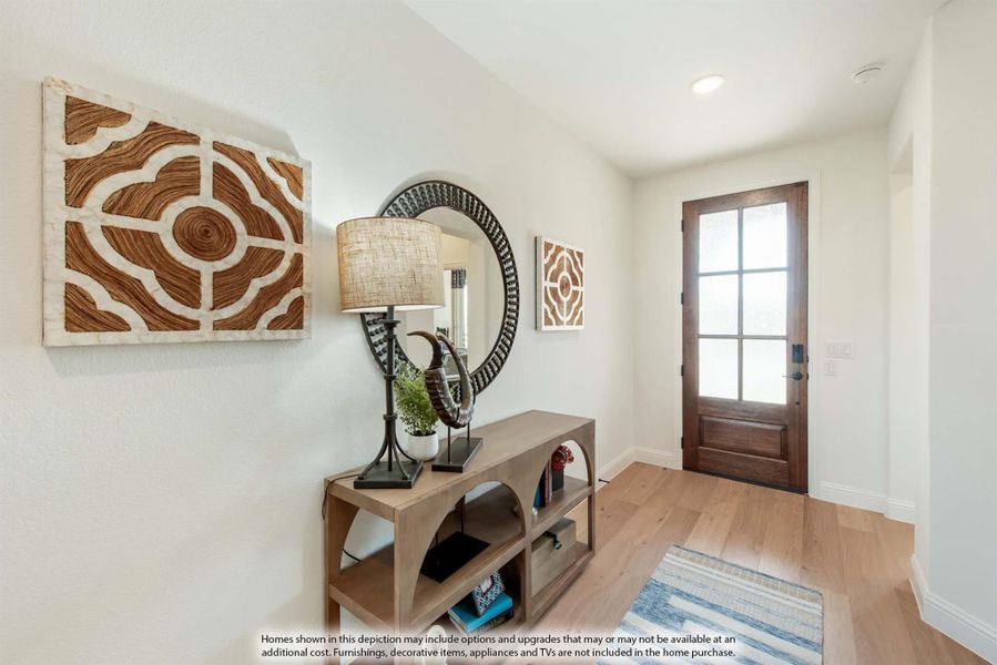 Entryway with wood console table, round mirror, wall art, and wood front door with glass panels on light hardwood floors Entryway with wood console table, round mirror, wall art, and wood front door with glass panels on light hardwood floors