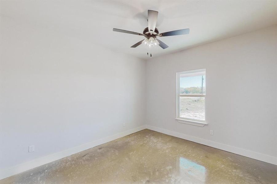 Empty room with ceiling fan and concrete floors