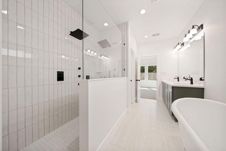 A lavish primary bath with a glass-enclosed shower, a freestanding tub, and a dual-sink vanity. A lavish primary bath with a glass-enclosed shower, a freestanding tub, and a dual-sink vanity.
