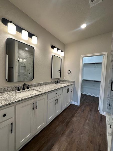 Bathroom featuring vanity, hardwood / wood-style flooring, and a shower with shower door