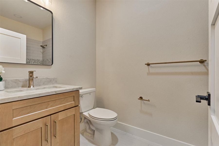 Dedicated full bath for bedroom 5 — equally perfect as a guest bath — with a natural wood vanity, framed mirror, warm gold fixtures, and a subway-tile shower with mosaic accent band. Private, stylish, and ready for family or overnight guests. Dedicated full bath for bedroom 5 — equally perfect as a guest bath — with a natural wood vanity, framed mirror, warm gold fixtures, and a subway-tile shower with mosaic accent band. Private, stylish, and ready for family or overnight guests.