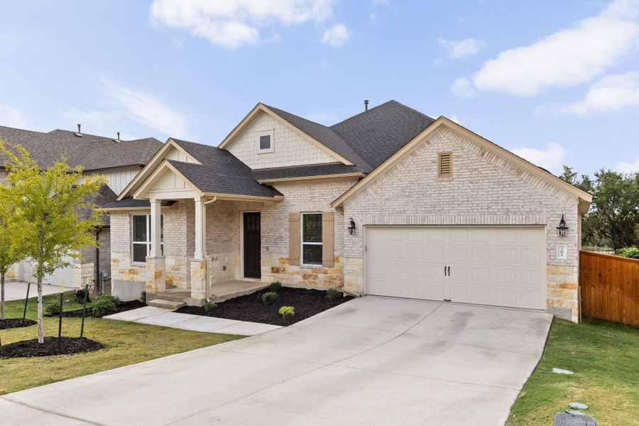 View of right side of house, including stone siding and a 2-car garage