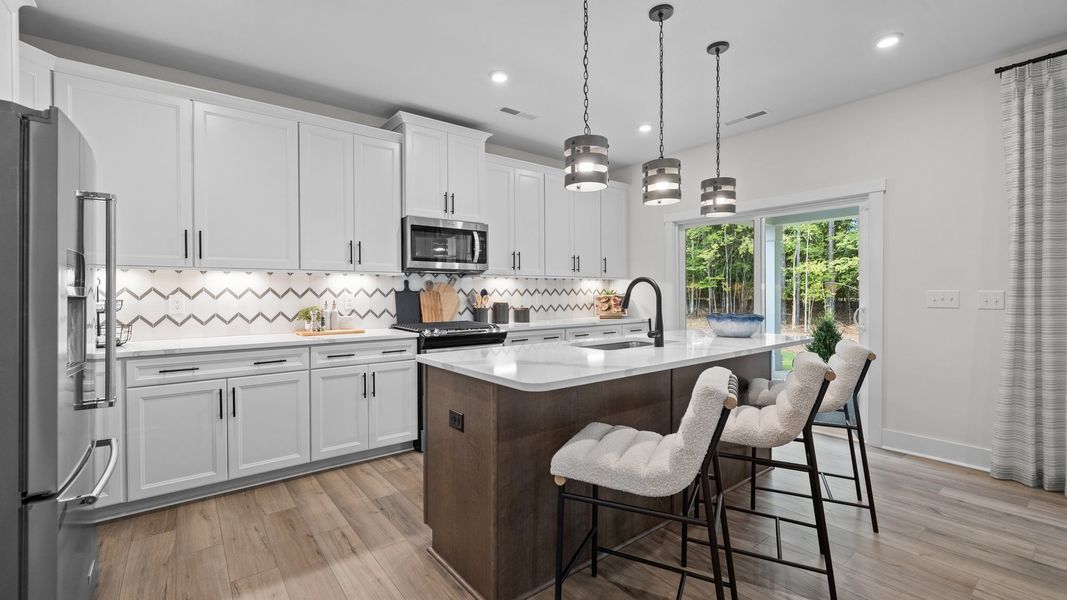 Kitchen with spacious island, premium backsplash, and pendant lighting in the Jordan Design by DRB Homes in York, SC