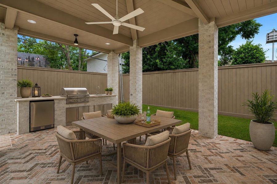 This covered outdoor living space features a fully equipped outdoor kitchen, that includes a ceiling fan, natural gas grill, sink and under-counter refrigerator - blending comfort with sophistication for effortless entertaining. Virtually staged to illustrate furnishing possibilities