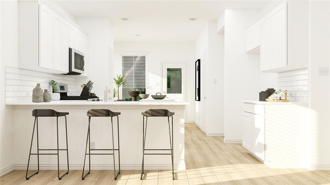 Kitchen with white cabinetry, tasteful backsplash, light hardwood / wood-style floors, kitchen peninsula, and a breakfast bar area