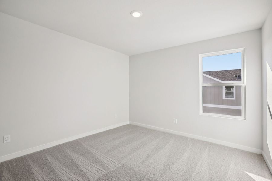 A room with a carpet and a window.