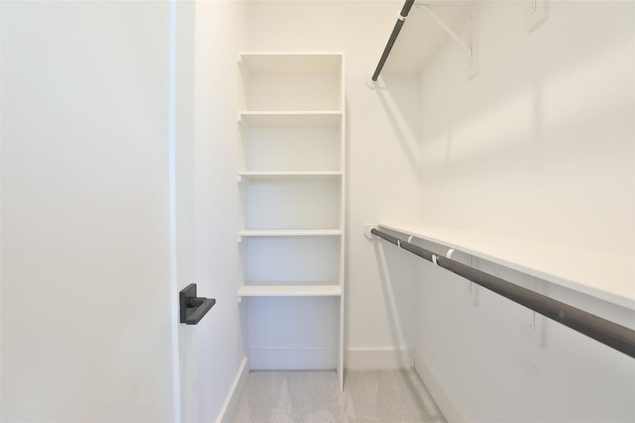 A spacious primary walk-in closet with plenty of room for shoes, accessories, and more.