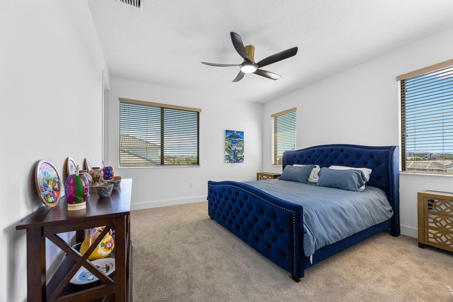 Bedroom featuring light colored carpet and ceiling fan