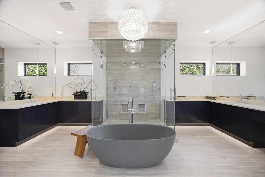 The ensuite bath is a true focal point, centered around a sculptural freestanding soaking tub and a fully enclosed glass shower.
