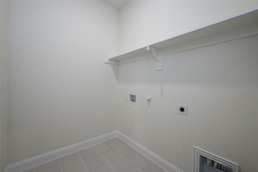 Washroom featuring tile patterned floors, electric dryer hookup, washer hookup, and hookup for a gas dryer