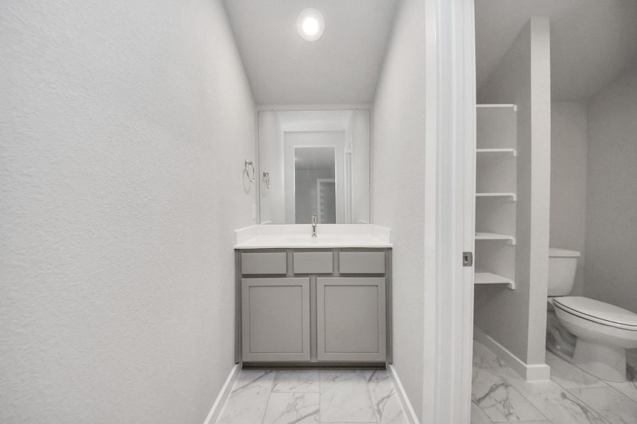 Experience convenience in the secondary bathroom, designed for Jack and Jillarrangements, now with a separate vanity area. This well-appointed spaceshowcases stylish tile flooring, a bath/shower combo with an elegant tilesurround, and light-stained wood cabinets. The beautiful light countertop adds atouch of sophistication, combining functionality and aesthetics seamlessly.