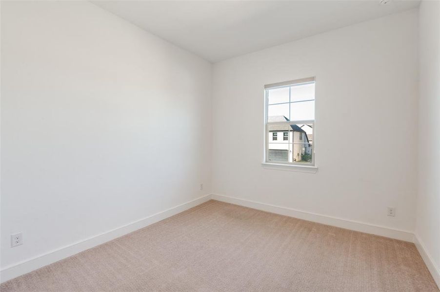 Upstairs bedroom with light colored carpet and baseboards Upstairs bedroom with light colored carpet and baseboards