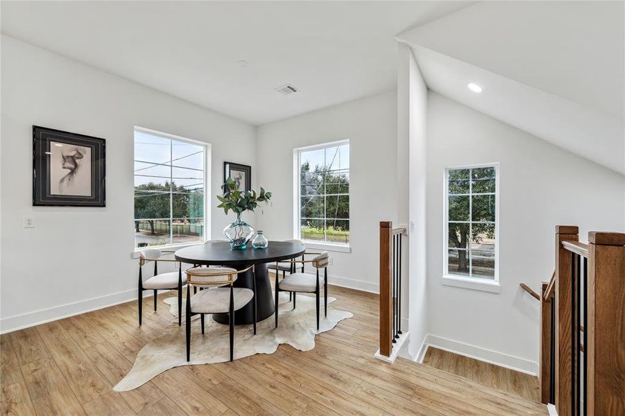 Bright and inviting dining area with large windows offering scenic views, perfect for gatherings.