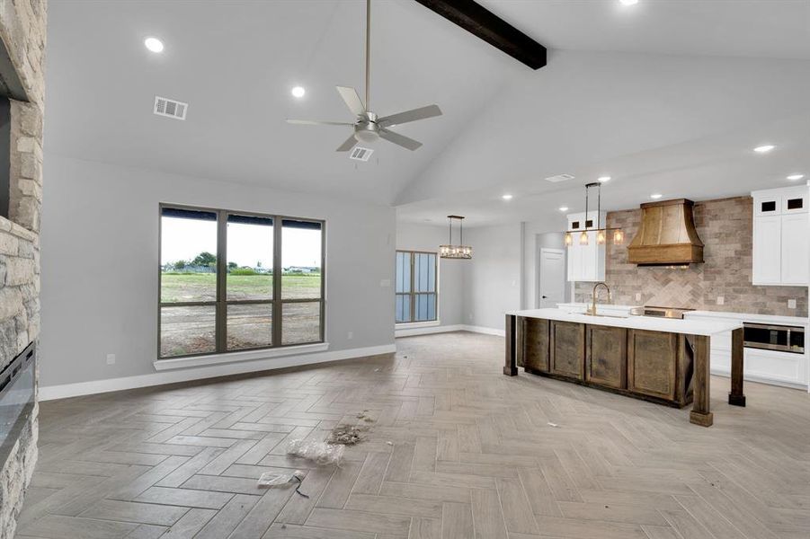 Kitchen featuring beam ceiling, recessed lighting, white cabinets, glass insert cabinets, and tasteful backsplash