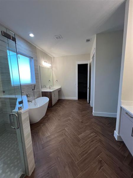 Bathroom featuring parquet flooring, vanity, and independent shower and bath