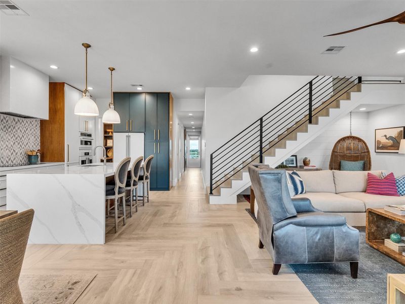 Step inside and feel at home in this open-concept layout flowing from the mudroom to the kitchen, breakfast bar, and living area. Gorgeous herringbone-patterned floors, natural light, and warm tones create a stylish, welcoming space. Smart Lutron lighting with programmable scene control adds effortless ambiance as you relax or entertain after a beach day. Step inside and feel at home in this open-concept layout flowing from the mudroom to the kitchen, breakfast bar, and living area. Gorgeous herringbone-patterned floors, natural light, and warm tones create a stylish, welcoming space. Smart Lutron lighting with programmable scene control adds effortless ambiance as you relax or entertain after a beach day.