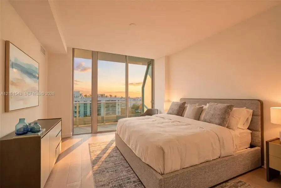 Floor-to-ceiling windows, sliding glass door leading to a private balcony, light-toned wood-finish flooring, and neutral wall finishes