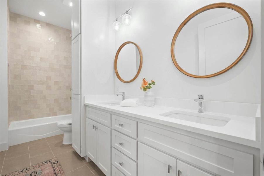 Upstairs on the main floor there is a guest powder room, while the first floor provides this full guest/secondary bathroom with a gorgeous dual vanity and a shower/tub combo.