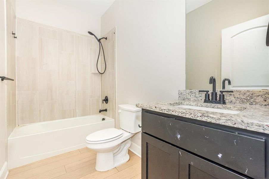 Full bath with vanity, tub / shower combination, and light wood-style floors Full bath with vanity, tub / shower combination, and light wood-style floors