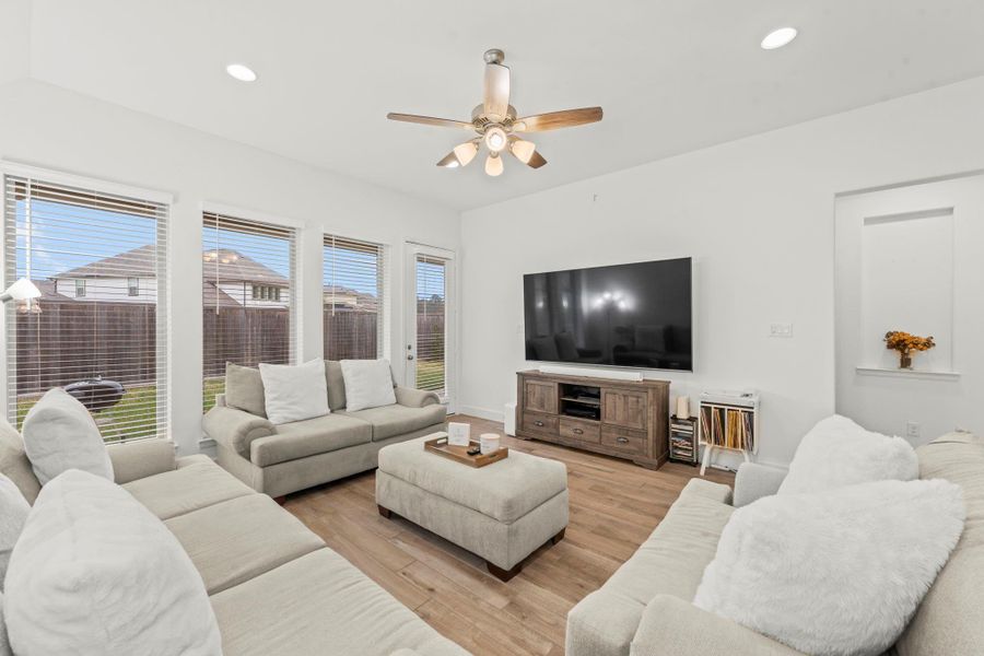 This beautifully designed Family Room blends style and function, featuring warm wood-look tile flooring and a sloped ceiling. A lighted ceiling fan adds both comfort and charm. Conveniently located just off the kitchen and dining areas, this open-concept space makes it easy to stay connected while entertaining or enjoying everyday moments.