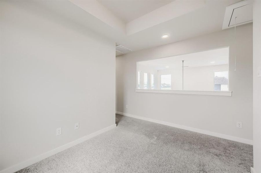 Carpeted room with a wide interior window