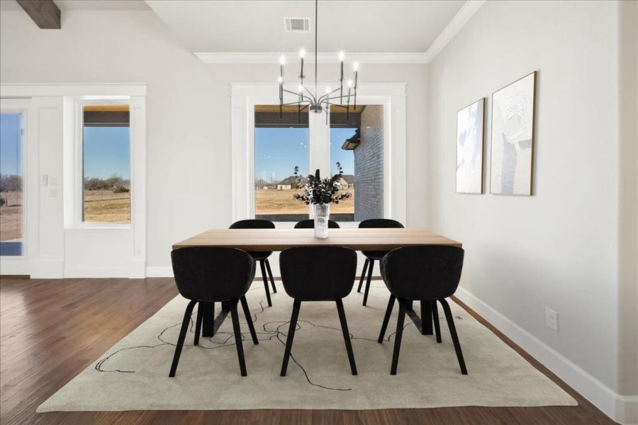 Dining area with hardwood / wood-style flooring, crown molding, a healthy amount of sunlight, and a notable chandelier