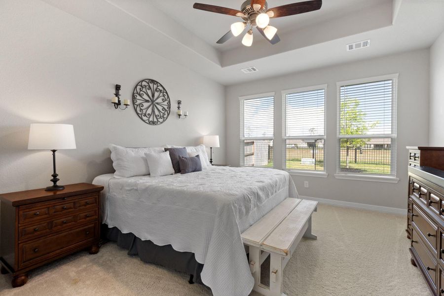 Spacious primary bedroom on the first floor with great views of the lake behind the home.