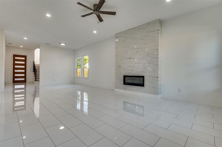 Unfurnished living room featuring recessed lighting, a fireplace, stairs, a ceiling fan, and light tile patterned floors