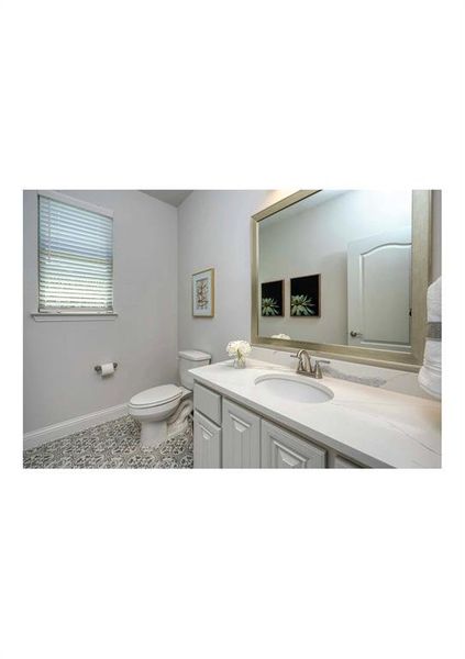 Bathroom with vanity, toilet, and tile patterned flooring