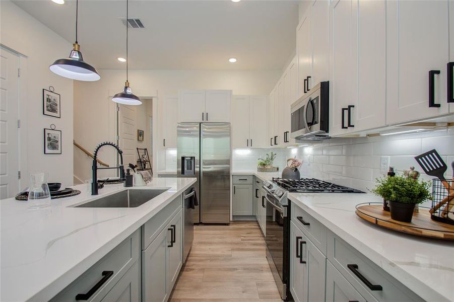 This attractive Kitchen is full of beautiful details. Quartz Countertops, Stainless Sink, Stainless Steel Appliances, Recessed Lighting and pendant lights, Undercabinet Lighting, Elegant Cabinetry with Soft Close Drawers and Doors. UNDER CONSTRUCTION!!  Photos from another community's model home FINISHES & COLORS MAY VARY! Ceiling fans are not included!