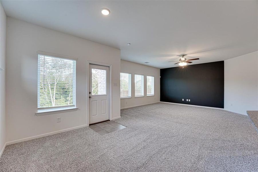 Spare room featuring light carpet, plenty of natural light, and ceiling fan