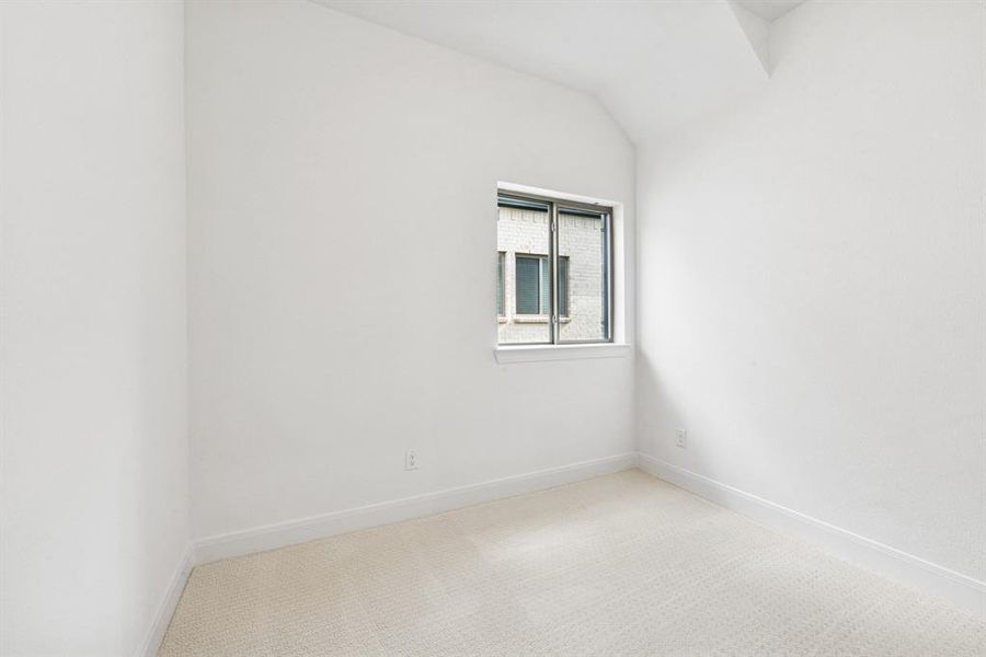 Spare room featuring light carpet and vaulted ceiling Spare room featuring light carpet and vaulted ceiling