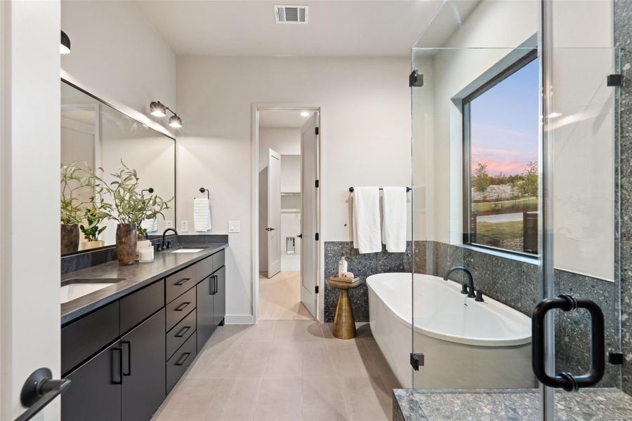 A well-appointed bath features a dual vanity, a soaking tub, and a spacious glass-enclosed shower. A well-appointed bath features a dual vanity, a soaking tub, and a spacious glass-enclosed shower.