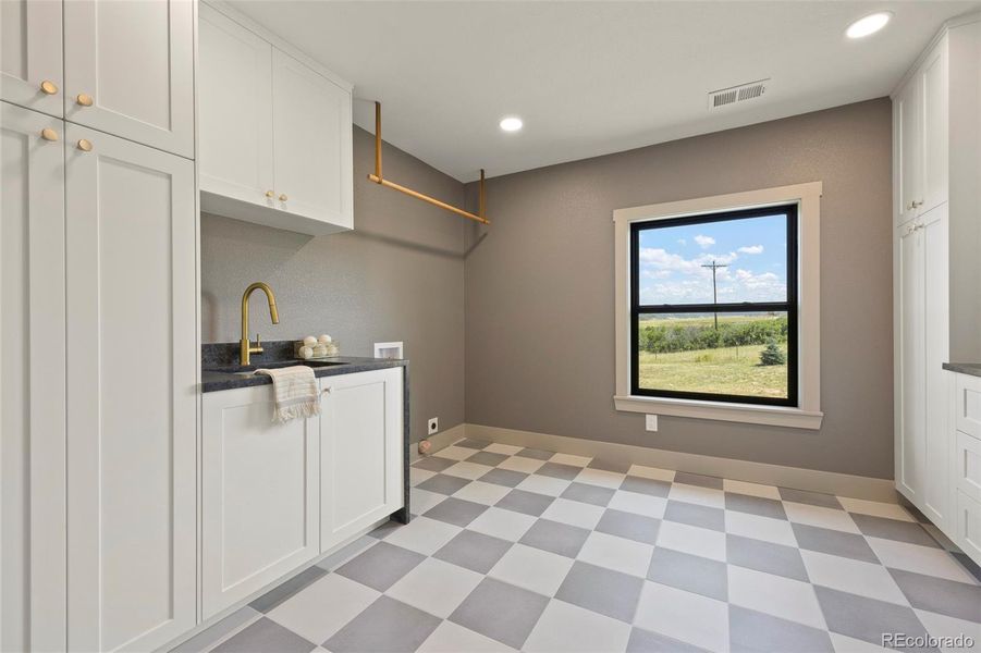 Laundry room with custom cabinetry and space for double stackable W/D