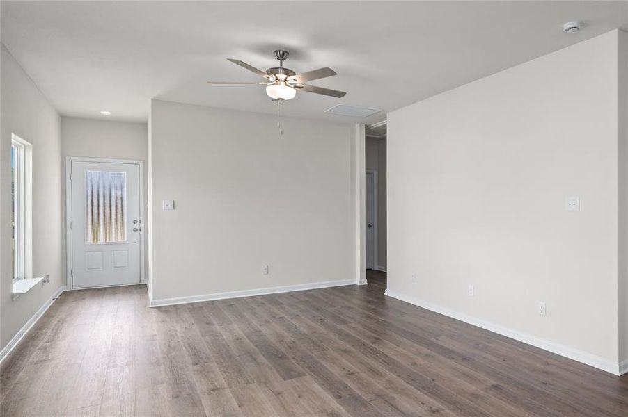 Spare room featuring wood finished floors, ceiling fan, and attic access